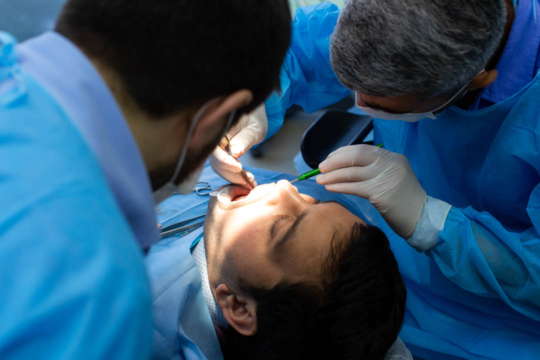 Cirugía bucal realizada por un dentista y su asistente en la Clínica Dental Augusto Leguía