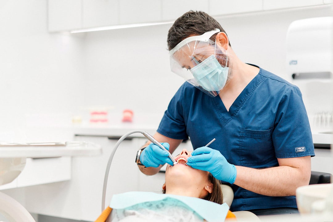 Cirujano realizando procedimiento periodontal en Clínica Dental Augusto Leguía