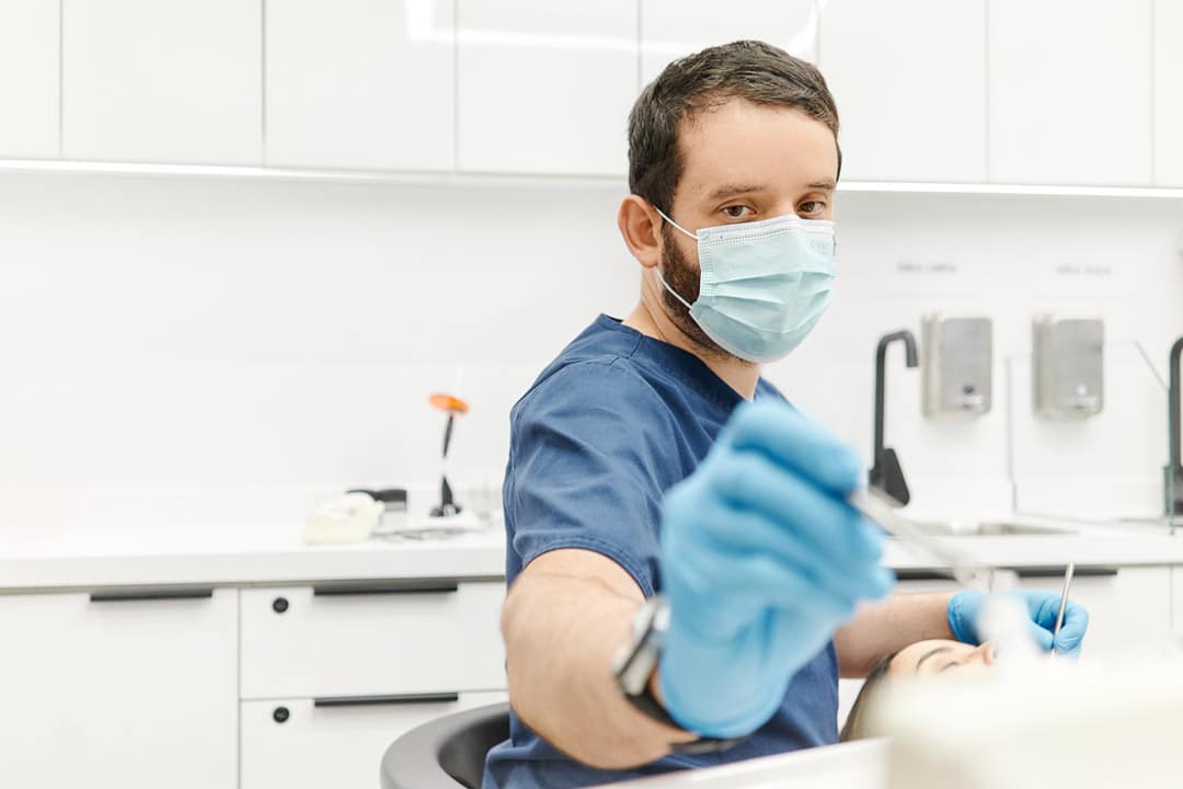 Dentista realizando procedimiento de rehabilitación oral en Clínica Dental Augusto Leguía