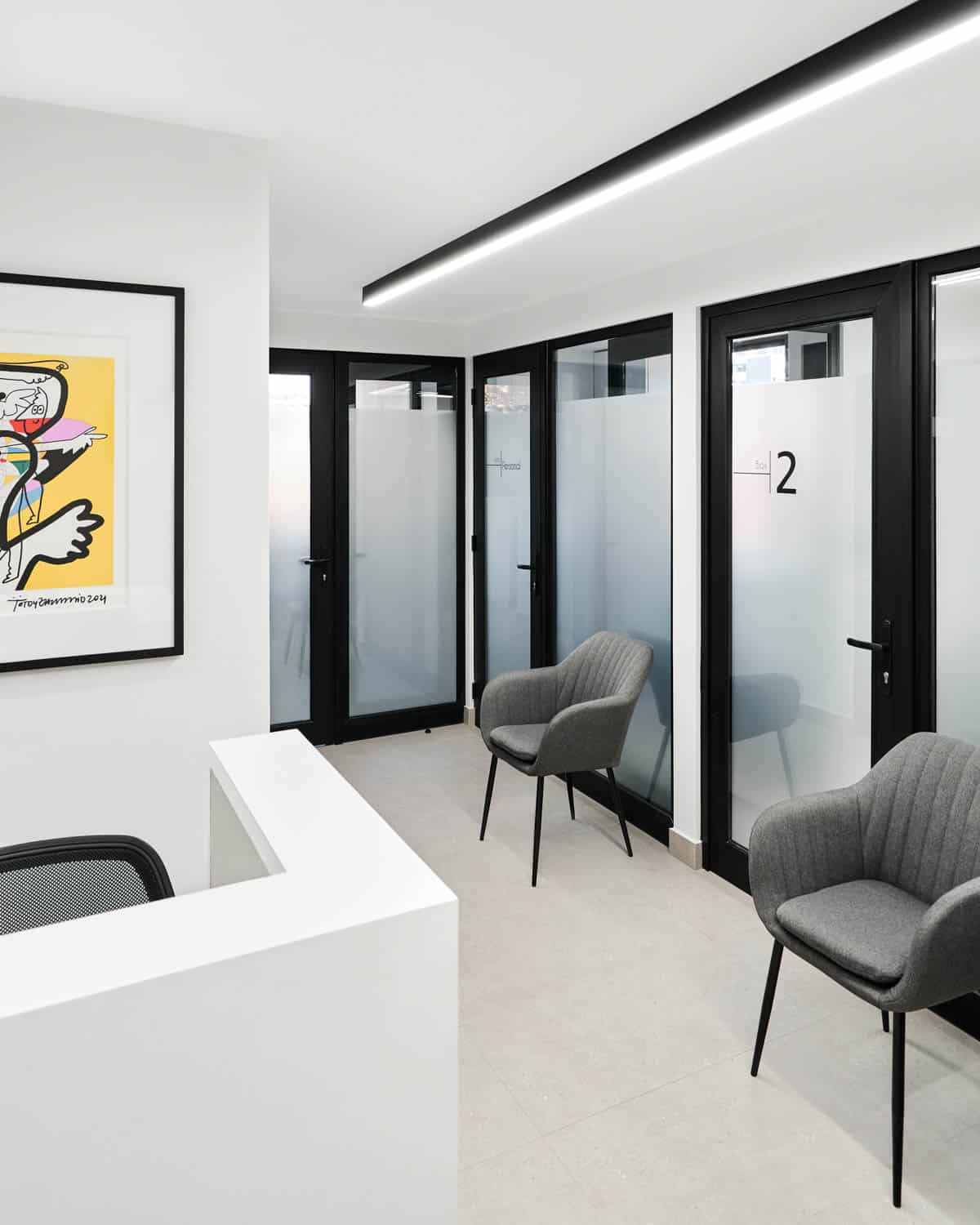 Sala de espera con vista a los box en la clínica dental Augusto Leguía, Las Condes